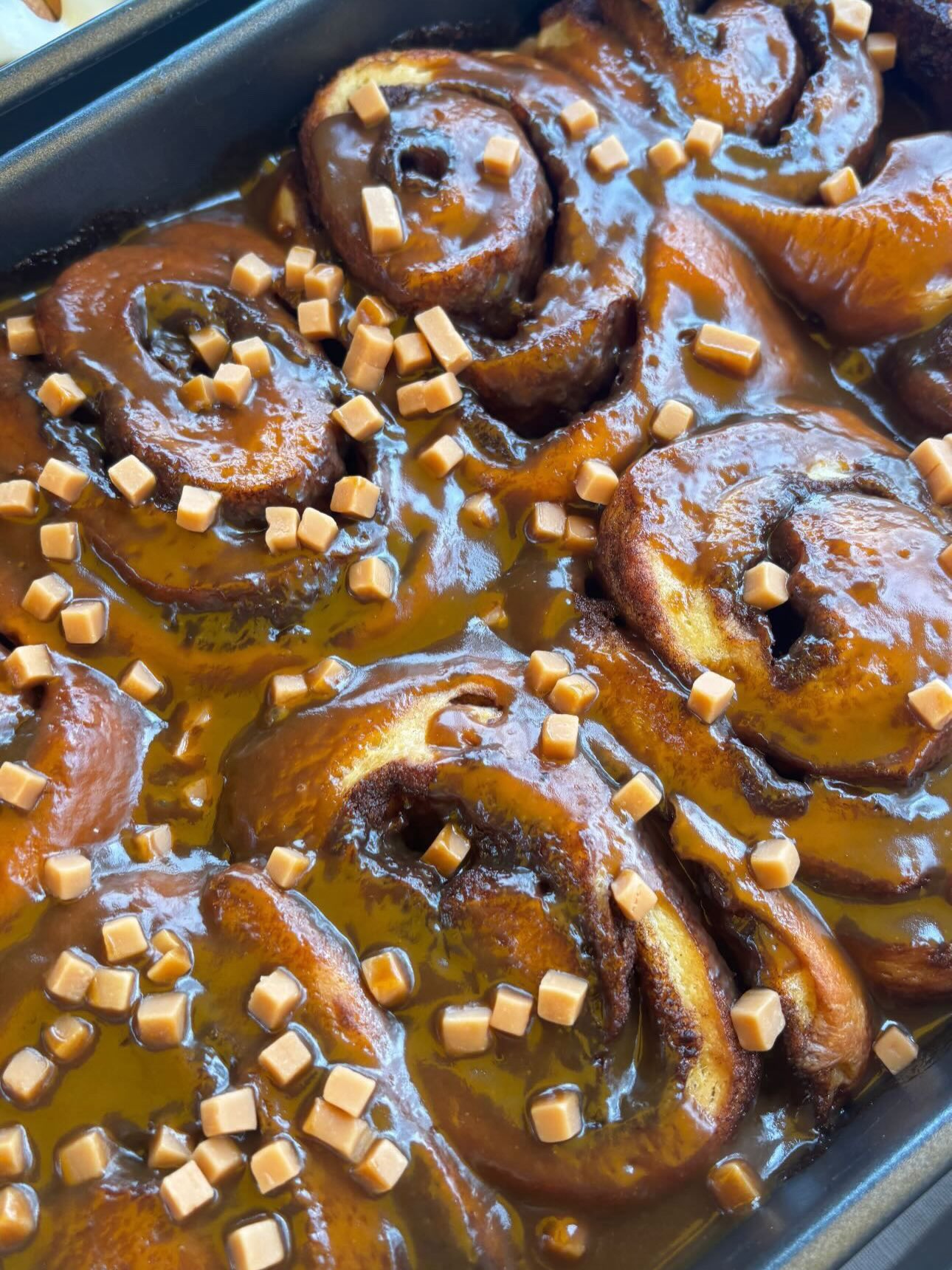 A tray of glossy caramel-coated buns