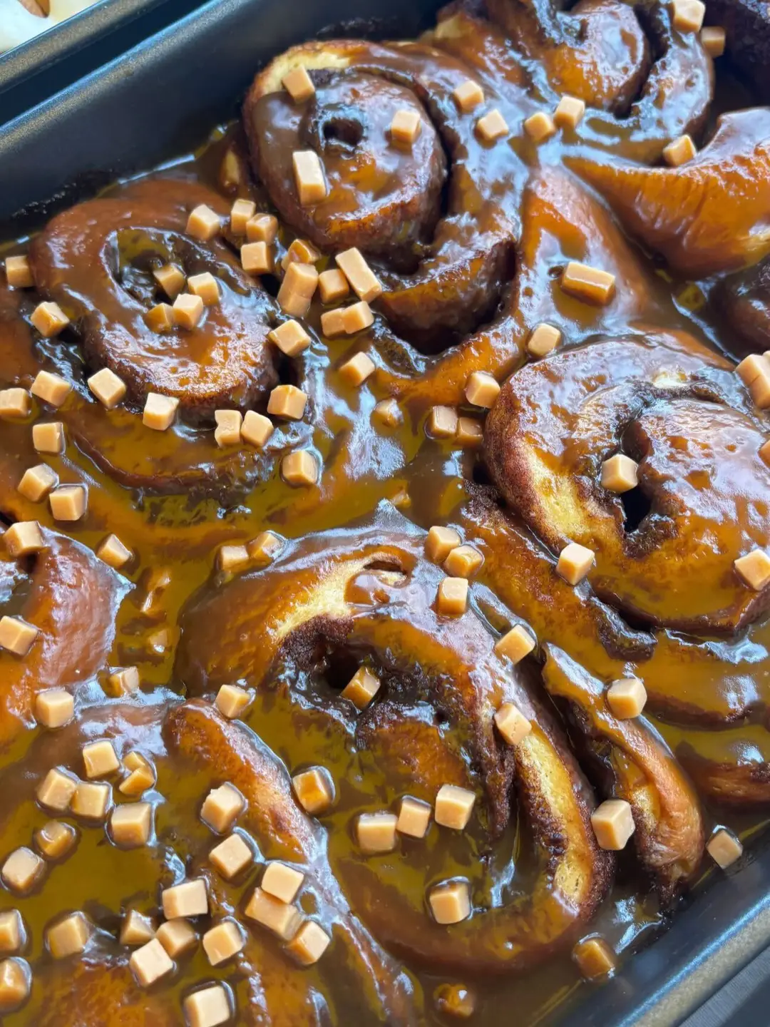 A tray of glossy caramel-coated buns